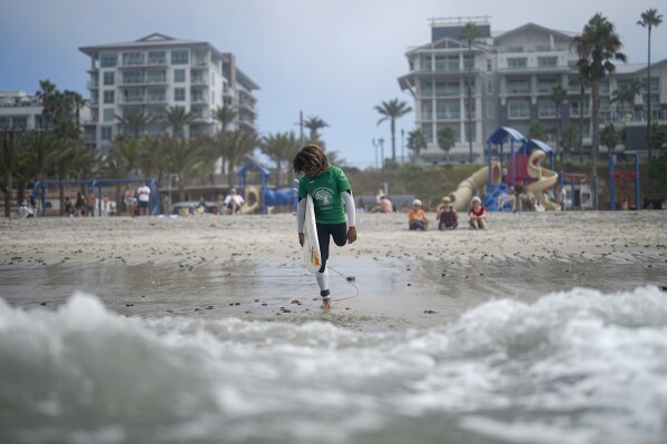 FILE - Dariel Melendez Davial, of Costa Rica, gets ready to enter the water during the U.S. Open Adaptive Surfing Championships, Sept. 8, 2023, in Oceanside, Calif. (AP Photo/Gregory Bull, File)