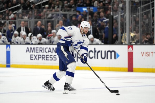 FILE - Tampa Bay Lightning defenseman Victor Hedman (77) hits the puck during the first period of an NHL hockey game against the Los Angeles Kings Saturday, March 23, 2024, in Los Angeles. Two-time Stanley Cup champion defenseman Victor Hedman has signed a four-year, $32 million extension with the Tampa Bay Lightning, a deal that will keep him under contract with the team through the 2028-29 season. General manager Julien BriseBois announced the move Tuesday, July 2. (AP Photo/Jae C. Hong, File)