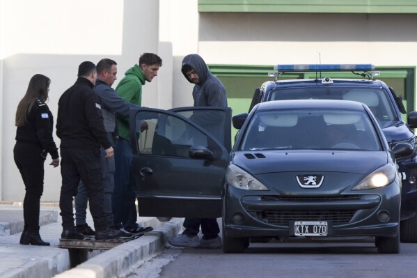 FILE - Police escort French rugby players Oscar Jegou, second from right, and Hugo Auradou, right, from jail after they were given house arrest in Mendoza, Argentina, July 17, 2024. The players were arrested following charges of sexual assault after France played Argentina in Mendoza on July 6. (AP Photo/Mariana Villa, File)