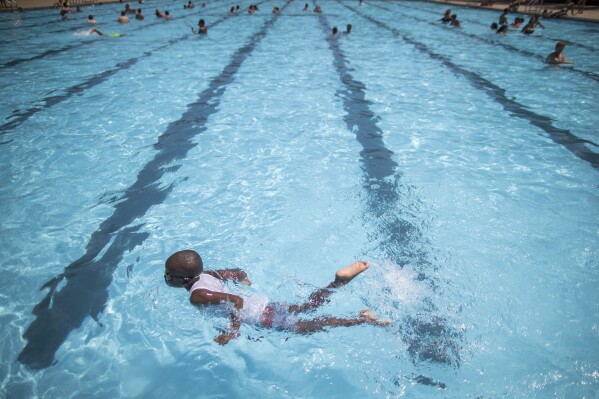 FILE - Children cool off at the Hamilton Fish pool, July 18, 2017, in the Lower East Side neighborhood of Manhattan. In most cases, there’s no need to wait at least 30 minutes after eating to go for a swim, doctors say. (AP Photo/Mary Altaffer, File)