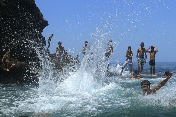 FILE - Youth play at the beach in a western part of Algiers, Monday, July 17, 2023. The young people who make up more than half of Algeria's population are so disenchanted that they may not vote in next month's presidential election. (AP Photo/Anis Belghou, File)