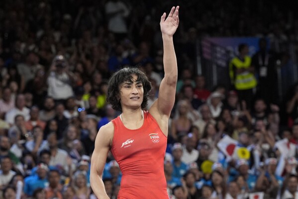 CORRECTS NAME TO VINESH PHOGAT, NOT VINESH VINESH - India's Vinesh Phogat celebrates after defeating Cuba's Yusneylys Guzman during their women's freestyle 50kg wrestling semifinal match, at Champ-de-Mars Arena, during the 2024 Summer Olympics, Tuesday, Aug. 6, 2024, in Paris, France. (AP Photo/Eugene Hoshiko)