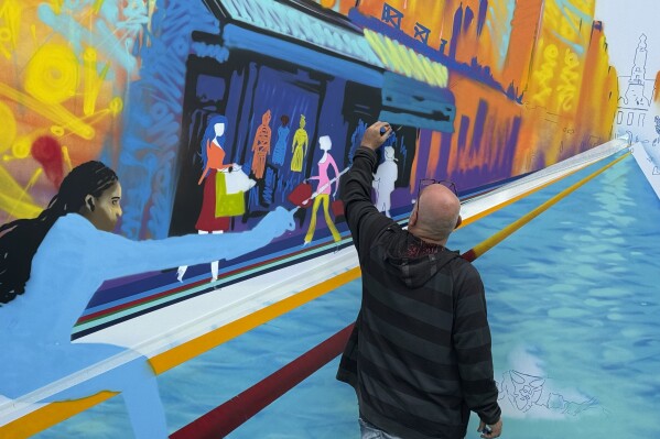 Street artist Marko93 works on a piece during a live artistic performance at City Hall, during the 2024 Summer Olympics, Wednesday, July 31, 2024, in Paris, France. (AP Photo/Jonathan Landrum)