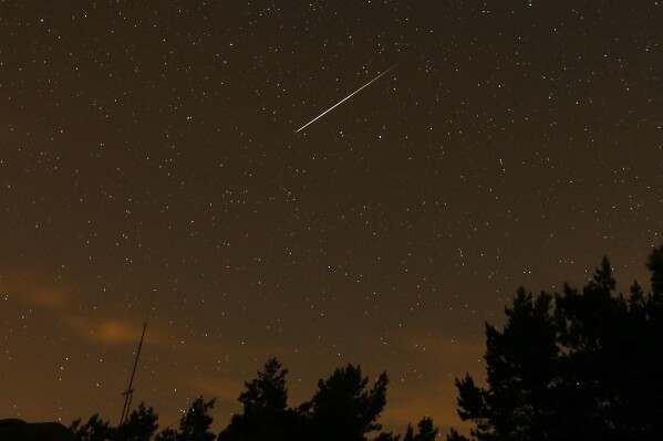 FILE - In this long exposure photo, a streak appears in the sky during the annual Perseid meteor shower at the Guadarrama mountains, near Madrid, in the early hours of Aug. 12, 2016. (AP Photo/Francisco Seco, File)