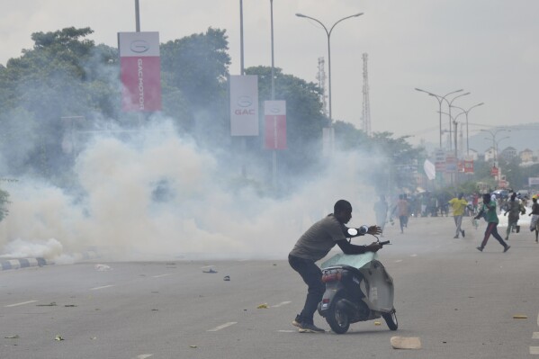 FILE - Police fired tear gas during a protest in Abuja, Nigeria, Thursday, Aug. 1, 2024. Nigeria’s leader on Sunday, Aug. 4, called for an end to mass protests against the West African nation’s economic hardship, saying the rallies have turned violent and have become politically motivated. (AP Photo/Olamikan Gbemiga, File)