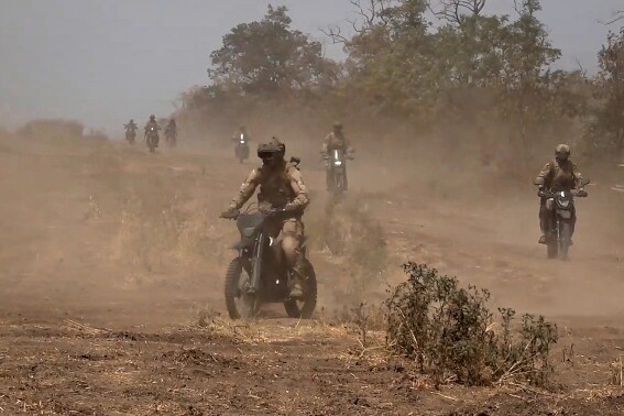 In this photo taken from video released by Russian Defense Ministry Press Service on Monday, Aug. 12, 2024, marine assault team members ride motorcycles toward Ukrainian position at an undisclosed location. (Russian Defense Ministry Press Service photo via AP)