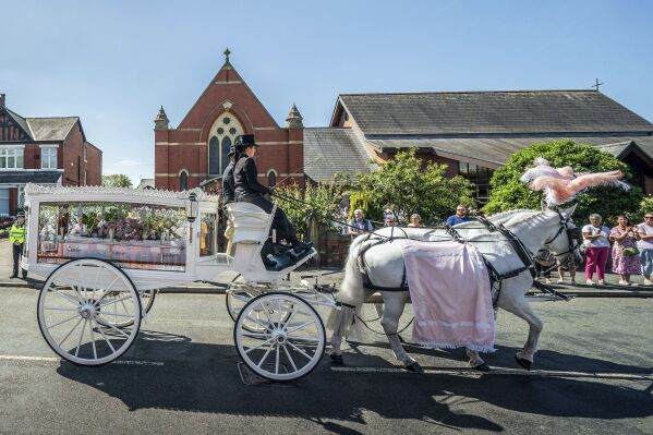 The horse-drawn carriage carrying the coffin of stabbing victim Alice da Silva Aguiar arrives for her funeral at St Patrick's Church, Southport, England, Sunday Aug. 11, 2024. (Danny Lawson/PA via AP)