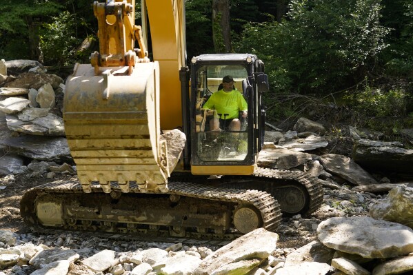 A crew member works on the removal of the Shulls Mill Dam on the Watauga River, near Boone, N.C., Monday, July 1, 2024. (AP Photo/Erik Verduzco)