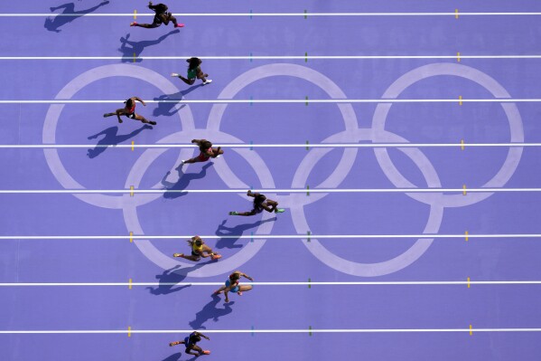 Sha'carri Richardson, right, of the United States, runs in women's 100-meter heat at the 2024 Summer Olympics, Friday, Aug. 2, 2024, in Saint-Denis, France. (AP Photo/David J. Phillip)