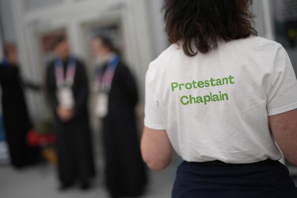 A woman wears a t-shirt to help distinguish religions in the religious area of the Olympic Village at the 2024 Summer Olympics, Tuesday, July 23, 2024, in Paris, France. (AP Photo/Rebecca Blackwell)