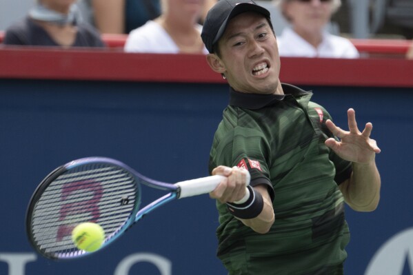 Japan's Ken Nishikori returns a shot to USA's Alex Michelson during their first round match at the National Bank Open tennis tournament in Montreal, Tuesday, Aug. 6, 2024. (Ryan Remiorz/The Canadian Press via AP)