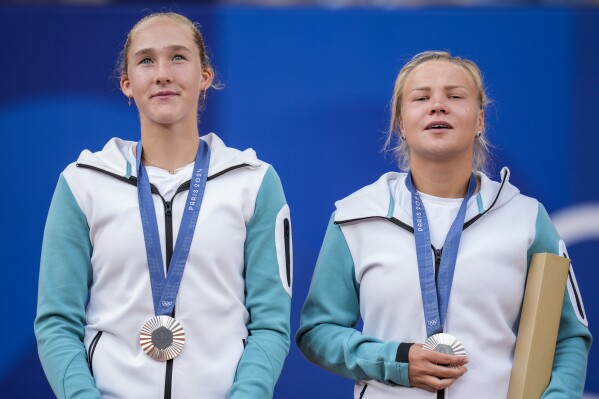 Andreeva and Diana Shnaider of Individual Neutral Athlete show their silver medals after losing to Sara Errani and Jasmine Paolini of Italy after women's doubles gold medal tennis match at the Roland Garros stadium, at the 2024 Summer Olympics, Sunday, Aug. 4, 2024, in Paris, France. (AP Photo/Manu Fernandez)