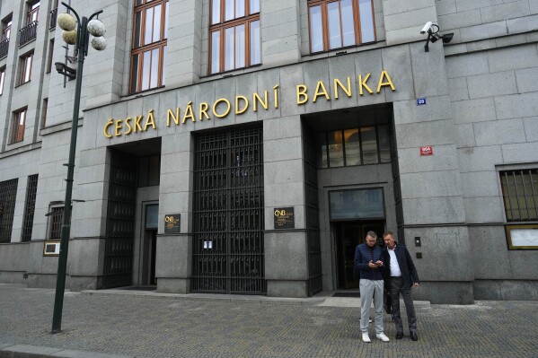 FILE - People stand outside the central bank in Prague, Czech Republic, on Nov. 2, 2023. The Czech Republic’s central bank on Thursday Aug. 1, 2024 cut its key interest rate for the sixth time in a row as inflation falls and the economy recovers more slowly than expected. (AP Photo/Petr David Josek, File)