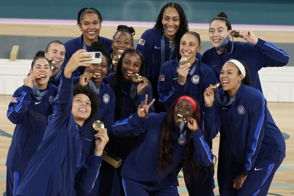 The United States team poses for a picture with their gold medals at Bercy Arena at the 2024 Summer Olympics, Sunday, Aug. 11, 2024, in Paris, France. (AP Photo/Michael Conroy)