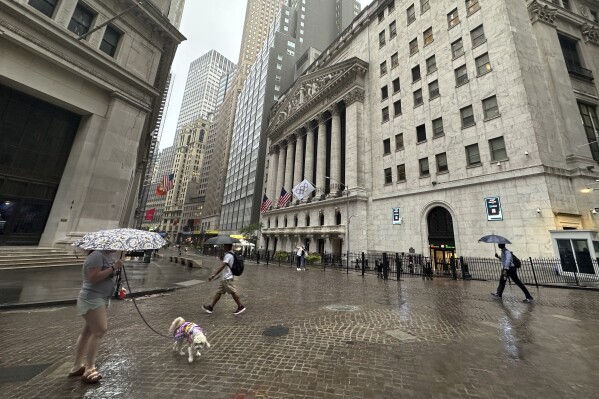 FILE - People walk past the New York Stock Exchange on Aug. 7, 2024 in New York. (AP Photo/Peter Morgan, File)