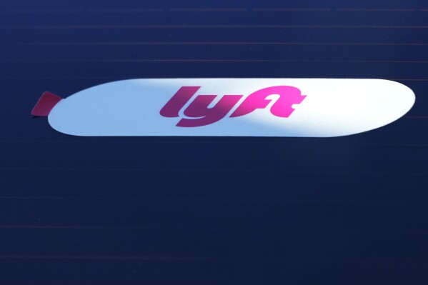 FILE - A Lyft sign is displayed on a car in Chicago, March 11, 2024. (AP Photo/Nam Y. Huh, File)