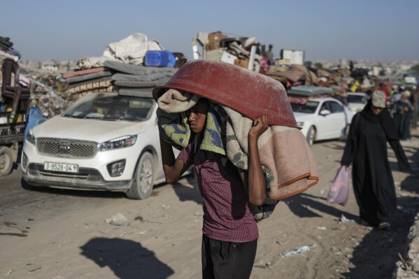 A Palestinian youth flees the Khan Younis area of the Gaza Strip, following Israeli military evacuation orders, saying its forces will soon operate there, Thursday, Aug. 8, 2024. (AP Photo/Abdel Kareem Hana)