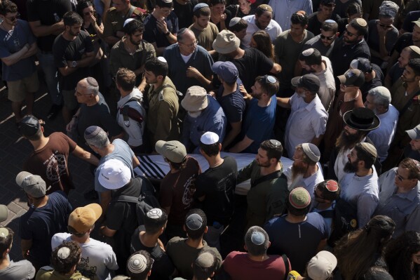 Relatives and friends of Yonatan Deutsch, who was killed in a drive-by shooting in the Israeli-occupied West Bank, carry his body during his funeral at a cemetery in Jerusalem, Monday, Aug. 12, 2024. (AP Photo/Leo Correa)