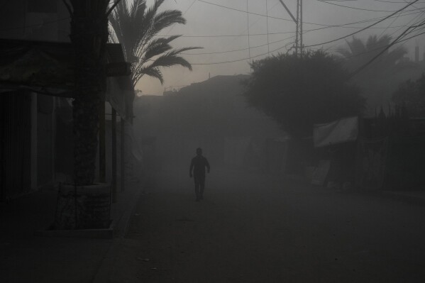 A Palestinian walks on a smoke-filled street after an Israeli airstrike in Deir al Balah, Gaza Strip, Tuesday, Aug. 6, 2024. (AP Photo/Abdel Kareem Hana)