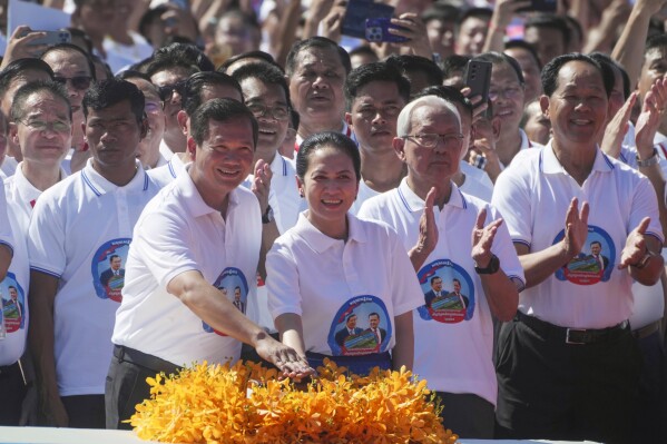 Cambodian Prime Minister Hun Manet, front left, accompanied by his wife Pich Chanmony, presses the button during a groundbreaking ceremony of China-funded Funan Techo canal that will connect the country’s capital Phnom Penh with Kep province on the country's south coast, Prek Takeo village, Kendal province, Cambodia, Monday, Aug. 5, 2024. (AP Photo/Heng Sinith)