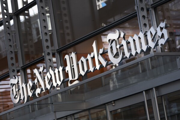 FILE - A sign for The New York Times hangs above the entrance to its building, May 6, 2021, in New York. (AP Photo/Mark Lennihan, File)