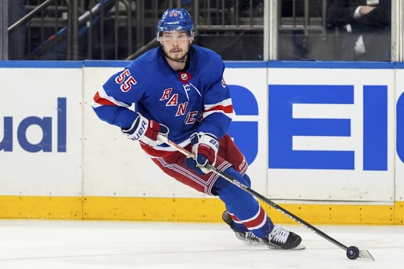 FILE - New York Rangers defenseman Ryan Lindgren (55) brings the puck up the ice during the third period of Game 1 of the NHL hockey Eastern Conference Stanley Cup playoff finals against the Florida Panthers, May 22, 2024, in New York. The New York Rangers avoided arbitration with Lindgren on Tuesday, July 30, signing the hard-nosed defenseman to a one-year contract. (AP Photo/Julia Nikhinson, File)