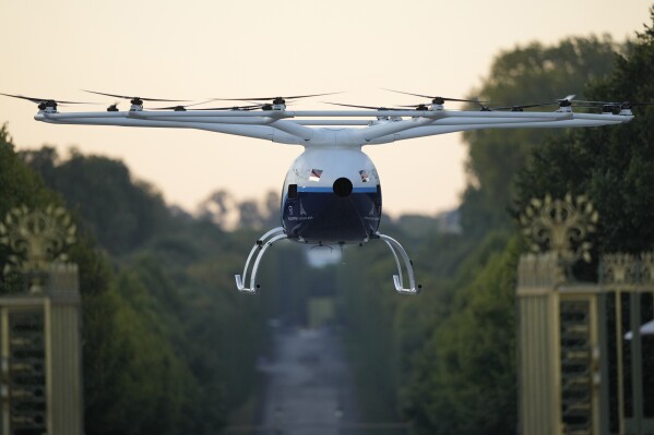 A Volocopter aircraft carries out a test flight on the last day of the 2024 Olympics with a sunrise demonstration at the 2024 Summer Olympics, Sunday, Aug. 11, 2024, in Versailles, France. (AP Photo/Mosa'ab Elshamy)