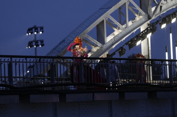 FILE - Drag queens prepare to perform on the Debilly Bridge in Paris, during the opening ceremony of the 2024 Summer Olympics, Friday, July 26, 2024. A storm of outrage about the Paris Olympics' opening ceremony took a legal turn Tuesday July 30, 2024, with a DJ who performed at the show saying her lawyer is filing complaints over a torrent of threats and other abuse that the LGBTQ+ icon has suffered online in the ceremony's wake. (AP Photo/Tsvangirayi Mukwazhi, File)