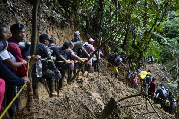 FILE - Migrants, mostly Venezuelans, walk across the Darien Gap from Colombia into Panama, hoping to reach the U.S., Oct. 15, 2022. Refugee agency UNHCR estimates more than 7.7 million Venezuelans have left since 2014, the largest exodus in Latin America’s recent history, with most settling in the Americas, from neighboring Colombia and Brazil to Argentina and Canada. (AP Photo/Fernando Vergara, File)