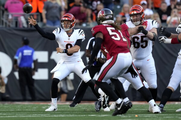 Cincinnati Bengals quarterback Joe Burrow (9) gets a pass away as Tampa Bay Buccaneers linebacker J.J. Russell (51) defends in the first half of an NFL preseason football game Saturday, Aug. 10, 2024, in Cincinnati. (AP Photo/Carolyn Kaster)