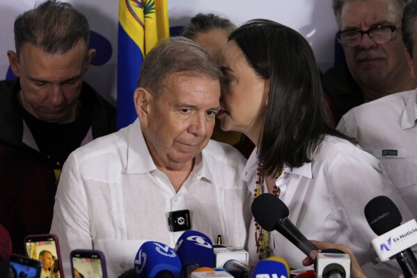 Opposition leader Maria Corina Machado talks to presidential candidate Edmundo Gonzalez during a press conference after electoral authorities declared President Nicolas Maduro the winner of the presidential election in Caracas, Venezuela, Monday, July 29, 2024. (AP Photo/Matias Delacroix)