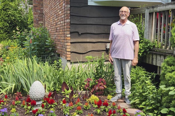 Jeff Kellert stands in his garden at his home in Albany, N.Y. on June 20, 2024. Kellert began volunteering as a tutor and helped with monthly dinners at his synagogue. The experience keeps him active, but just as important, he said, it has led to new friendships and a sense of purpose he never expected in retirement. (Robert Piechota via AP)