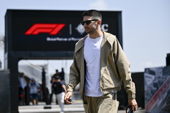 French Formula One driver Esteban Ocon of Alpine F1 Team arrives in the paddock ahead of the Hungarian Formula One Grand Prix at the Hungaroring racetrack in Mogyorod, near Budapest, Hungary, Thursday, July 18, 2024. The Hungarian F1 Grand Prix is held on Sunday, July 21, 2024. (AP Photo/Denes Erdos)