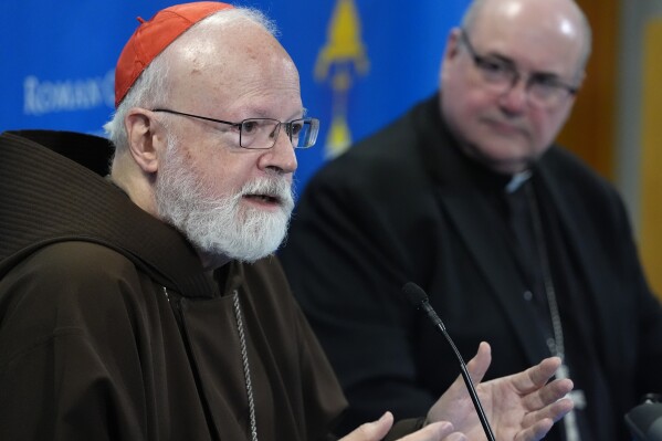 Cardinal Sean O'Malley, left, responds to a question from a reporter as bishop of Providence, R.I., Richard Henning, right, looks on during a news conference, Monday, Aug. 5, 2024, in Braintree, Mass. Pope Francis on Monday accepted the resignation of O'Malley as archbishop of Boston and named Henning, the current bishop of Providence, to replace him as leader of one of the most important Catholic archdioceses in the United States. (AP Photo/Steven Senne)