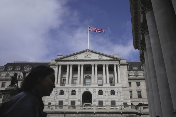 FILE - A woman walks in front of the Bank of England, at the financial district in London, on March 23, 2023. Inflation in the U.K. held steady at the Bank of England's target rate of 2% in the year to June, official figures showed Wednesday, July 17, 2024, in a development that could be enough for policymakers to cut borrowing costs next month. (AP Photo/Kin Cheung, File)