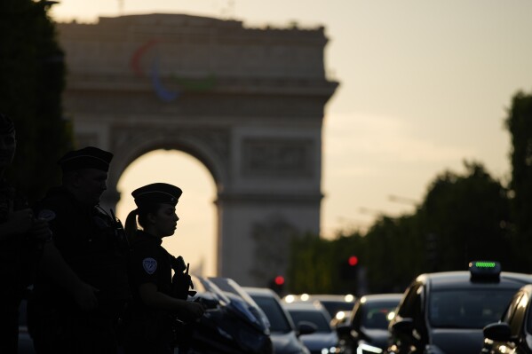 A police officer is silhouetted by the Arc de Triomphe after a stabbing near the Champs-Elysees avenue, Thursday, July 18, 2024, in Paris. (AP Photo/David Goldman)