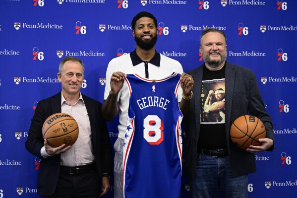 Philadelphia 76ers' Paul George center, owner Josh Harris, left, and president Daryl Morey pose for a photo at the NBA basketball team's practice facility, Tuesday, July 23, 2024, in Camden, N.J. (AP Photo/Derik Hamilton)