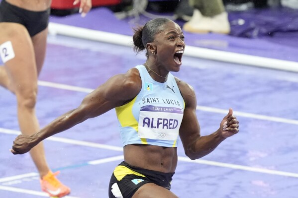 Julien Alfred, of Saint Lucia, celebrates after winning the women's 100 meters final at the 2024 Summer Olympics, Saturday, Aug. 3, 2024, in Saint-Denis, France. (AP Photo/Martin Meissner)