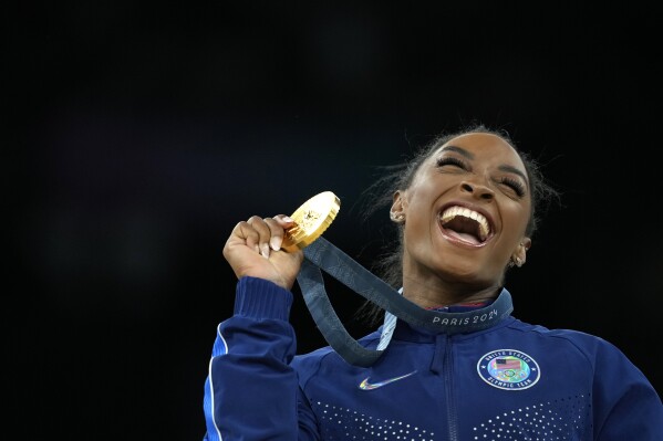 Simone Biles, of the United States, celebrates after winning the gold medal at the medal ceremony during the women's artistic gymnastics individual vault finals at Bercy Arena at the 2024 Summer Olympics, Saturday, Aug. 3, 2024, in Paris, France. (AP Photo/Francisco Seco)