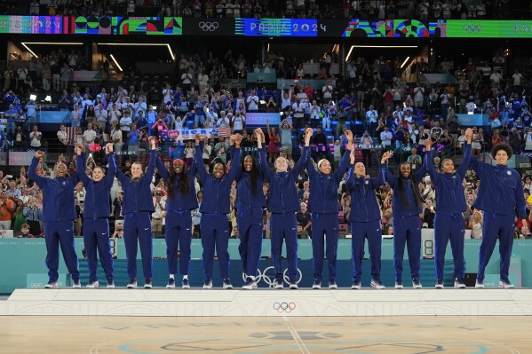 The United States team celebrates after winning gold medals at Bercy Arena at the 2024 Summer Olympics, Sunday, Aug. 11, 2024, in Paris, France. (AP Photo/Mark J. Terrill)