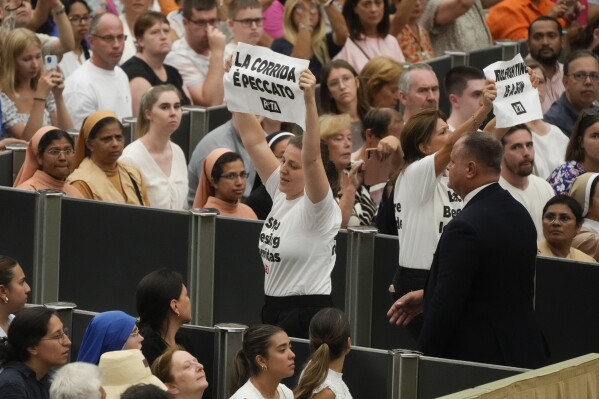 Protesters wear t-shirts reading: "stop blessing corridas" as they hold up placards with a writing "Bullfighting is a sin" during Pope Francis weekly general audience in the Paul VI hall at the Vatican, Wednesday, Aug. 7, 2024. (AP Photo/Gregorio Borgia)