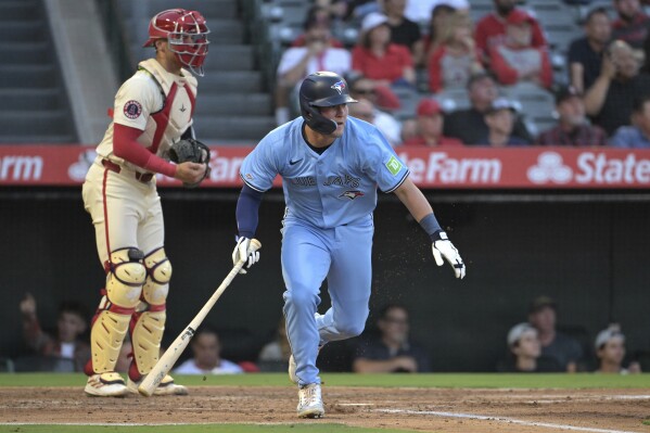 Toronto Blue Jays' Will Wagner, right, runs to first after hitting an RBI single during the third inning of a baseball game against the Los Angeles Angels, Monday, Aug. 12, 2024, in Anaheim, Calif. (AP Photo/Jayne-Kamin-Oncea)