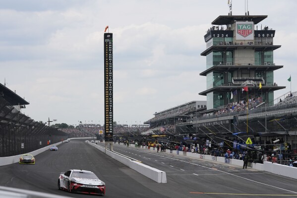 Denny Hamlin drives into a turn during a NASCAR Cup Series auto race at Indianapolis Motor Speedway, Sunday, July 21, 2024, in Indianapolis. (AP Photo/Darron Cummings)