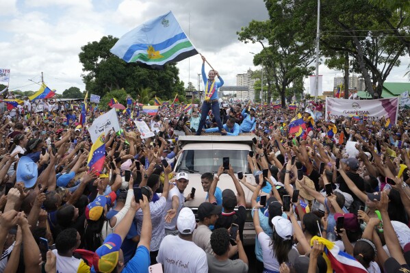 Opposition leader Maria Corina Machado waves a Monagas state flag as she greets supporters during a campaign rally for presidential candidate Edmundo Gonzalez, in Maturin, Venezuela, Saturday, July 20, 2024. The presidential election is set for July 28. (AP Photo/Matias Delacroix)