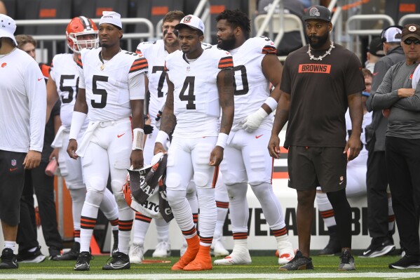 Cleveland Browns quarterbacks Jameis Winston (5) and Deshaun Watson (4) watch from the sideline during the first half of an NFL preseason football game against the Green Bay Packers, Saturday, Aug. 10, 2024, in Cleveland. (AP Photo/David Richard)