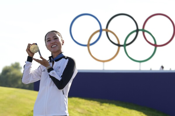 Lydia Ko, of New Zealand, poses for the cameras with her gold medal following final round of the women's golf event at the 2024 Summer Olympics, Saturday, Aug. 10, 2024, at Le Golf National, in Saint-Quentin-en-Yvelines, France. (AP Photo/Matt York)