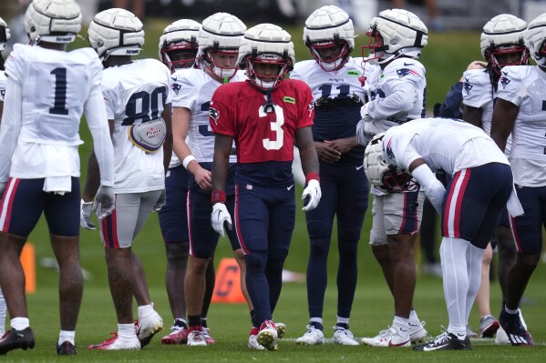 New England Patriots wide receiver DeMario Douglas (3) gathers with teammates during a football practice, Tuesday, Aug. 6, 2024, in Foxborough, Mass. (AP Photo/Charles Krupa)