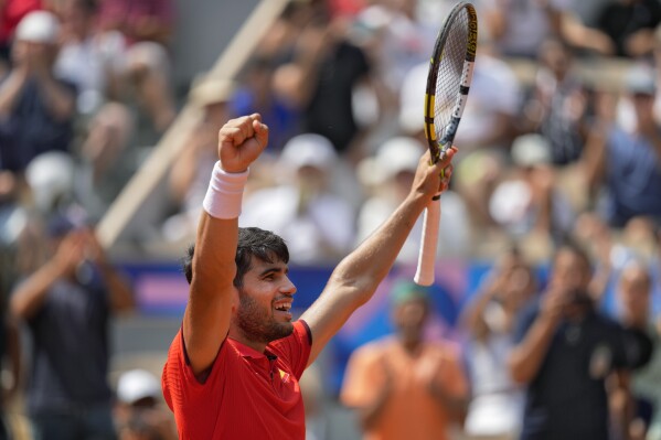 Carlos Alcaraz of Spain celebrates after defeating Felix Auger-Aliassime of Canada in their men's singles semifinals tennis match, at the 2024 Summer Olympics, Friday, Aug. 2, 2024, at the Roland Garros stadium in Paris, France. (AP Photo/Andy Wong)