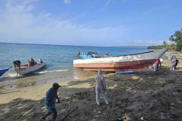 This photo provided by the Dominican Republic Civil Defense shows a boat retrieved by the Civil Defense from the sea off Rio San Juan, Dominican Republic, Tuesday, Aug. 6, 2024. Dominican forensic authorities said they are analyzing bones found in the vessel after receiving an alert from a local fisherman. (Dominican Republic Civil Defense via AP)