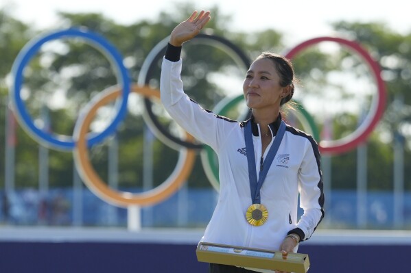 Lydia Ko, of New Zealand, waves to the crowd wearing her gold medal during the medal ceremony following the final round of the women's golf event at the 2024 Summer Olympics, Saturday, Aug. 10, 2024, at Le Golf National, in Saint-Quentin-en-Yvelines, France. (AP Photo/Matt York)